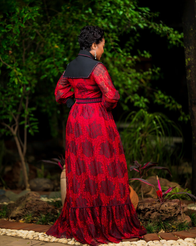 Red lace dress with black collar and cuff detailing.