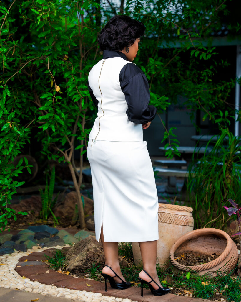 This sleek white two-piece outfit is beautifully tailored to create a clean, refined silhouette, with the structured sleeveless overlay adding a modern and sophisticated touch.